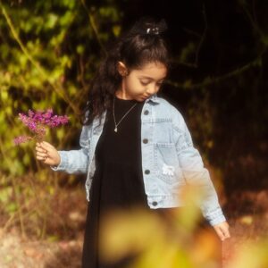 Charming portrait of a girl holding flowers in an autumn garden setting.