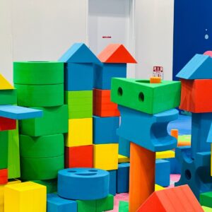 Vibrant foam building blocks stacked in an indoor children's play area.