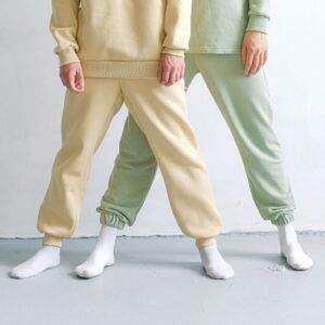 Studio shot showcasing minimalist fashion with two people in tracksuits and socks.