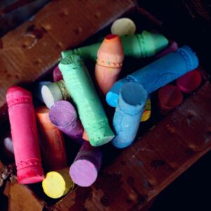 Bright and colorful assorted sidewalk chalks in a cardboard box. Perfect for art and creativity.